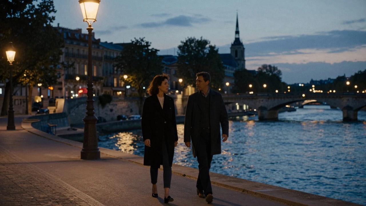 A man and woman walking quietly along the Seine in Passy under soft streetlamp glow.