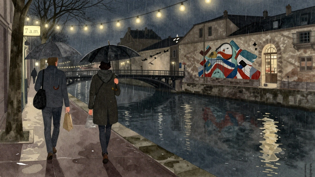 Two people walking under string lights along Canal Saint-Martin in the gentle rain.