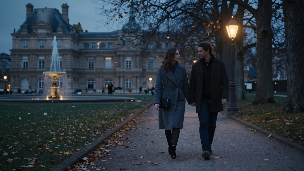 Two figures walking peacefully under autumn trees in the Luxembourg Gardens at night.