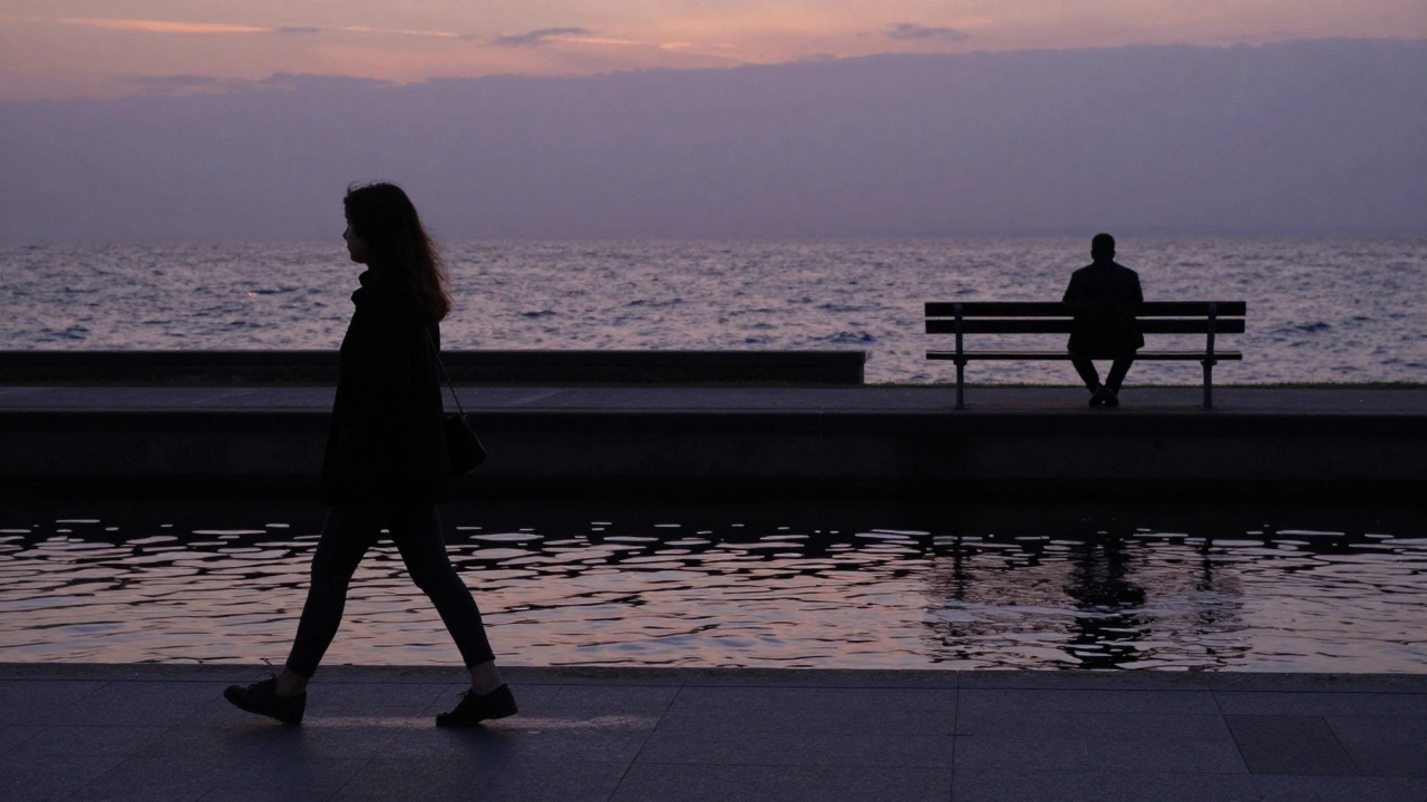 A woman walks by the canal at sunset, a distant figure watching peacefully in the background.