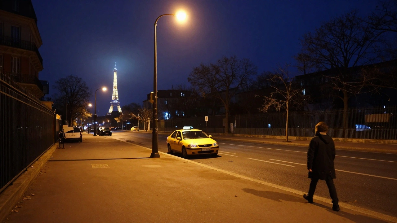 Empty Paris street at night with a taxi and distant tower silhouette.