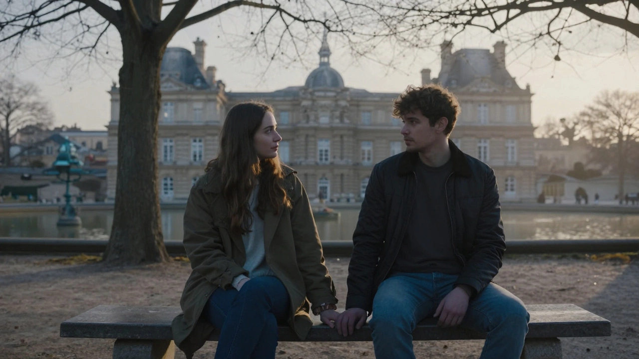 Two people sitting quietly on a bench at dawn near Luxembourg Gardens, hands nearly touching.